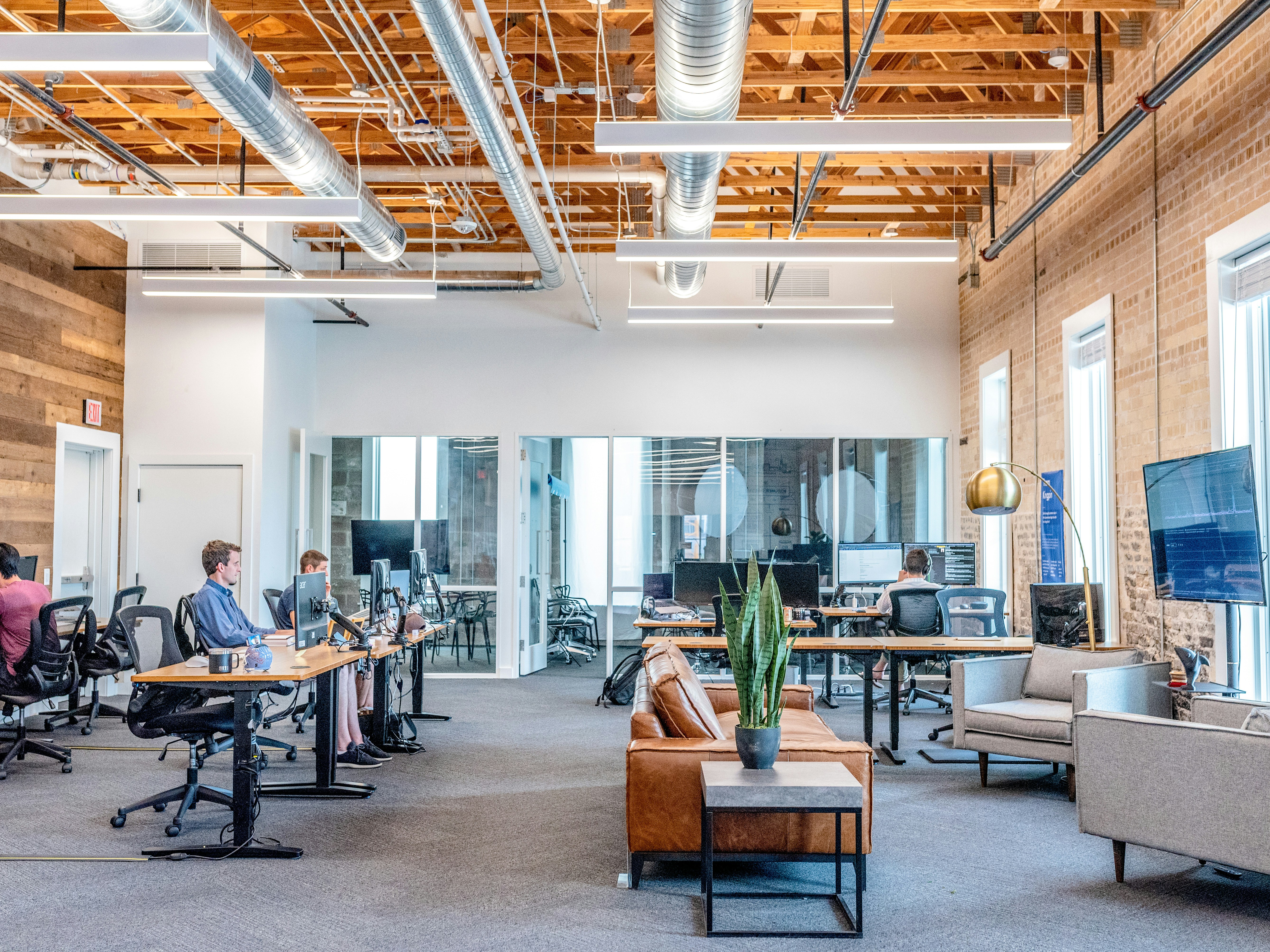 View of an open office with 3 people working on their computers